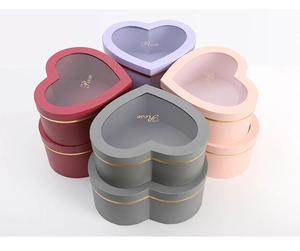 Detailed view of heart-shaped gift boxes with clear windows and Rose gold lettering