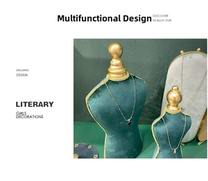 Detail view of gold pendant necklaces displayed on a green velvet bust stand portrait