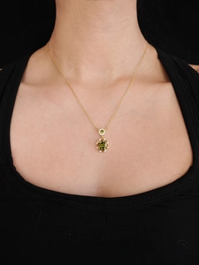 Detailed view of 18K gold plated necklace with oval green zircon and pavé crystals