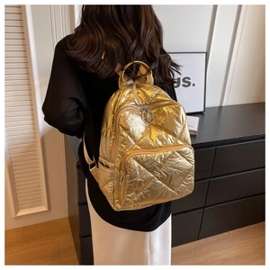 Detail eines goldenen gesteppten Rucksacks mit Metallic-Finish und mehreren Taschen