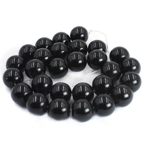 Close-up of polished black agate round beads showing smooth texture and high luster finish
