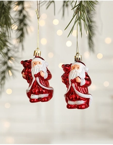 Close-up of red and white Santa Claus hanging ornaments on festive pine branches