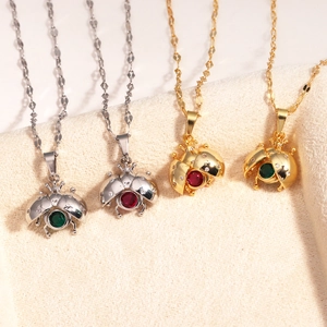 Close-up of four red and green enamel ladybug pendants with sparkling crystal inlay