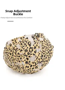 Detail of adjustable metal snap button on leopard print mesh beret for size adjustment