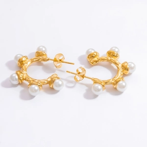 Macro detail of 18k gold plated stainless steel earring with pearl inlay and hammered texture