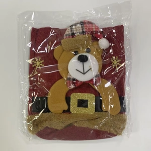 Detailed view of burlap Christmas gift bag with plush bear doll and snowflake patterns