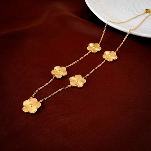 Détails de cinq pendentifs fleurs dorées à texture radiale sur du velours rouge foncé