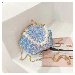 Detail of blue sequin shell bag with large pearl handle and golden chain strap