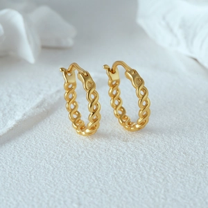 Detail of minimalist gold-plated silver chain link earrings with twisted rope texture