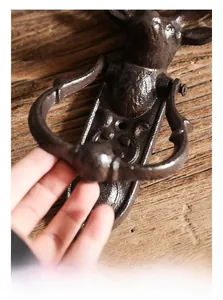 Gros plan d'un heurtoir de porte tête de cerf en fonte vintage au fini rustique