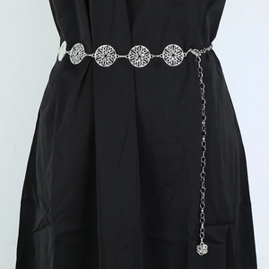 Detailed silver metal waist chain with hollow round patterns and a flower pendant charm