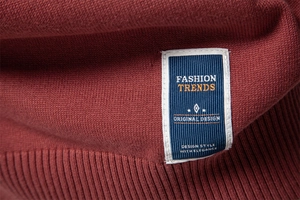 Vue macro détaillée de la texture du pull en tricot rouge foncé avec étiquette bleu marine