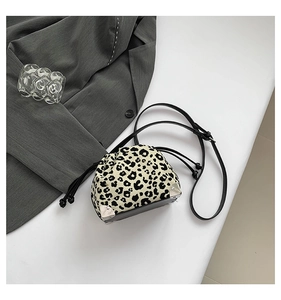 Detail of leopard print bucket bag featuring silver metal corners and black leather base