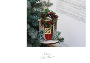 Detail of wooden Christmas door ornament with red finish, number 25, and snowy mini trees