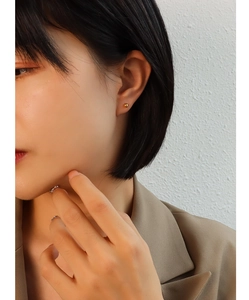 Close-up of minimalist round golden bean stud earrings with polished metallic finish