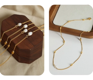 Detail of gold-plated titanium necklace with irregular freshwater pearls on wood box
