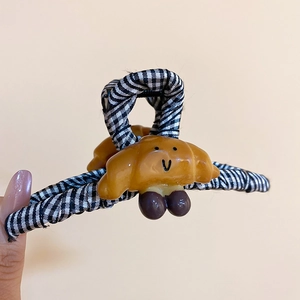 Détail macro d'une pince à cheveux croissant avec tissu à carreaux noir et blanc chic