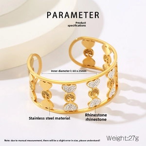 Close-up of golden Tree of Life cuff with heart patterns and inlaid white rhinestones