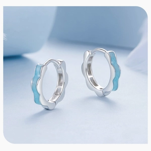 Macro shot of S925 sterling silver hoop earrings with light blue enamel lace pattern
