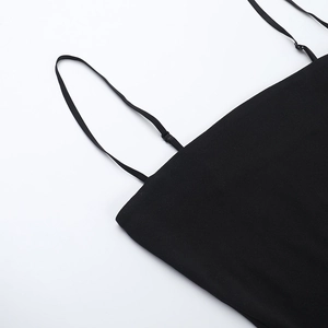 Detail of adjustable thin straps and ruffled fabric on a black backless dress