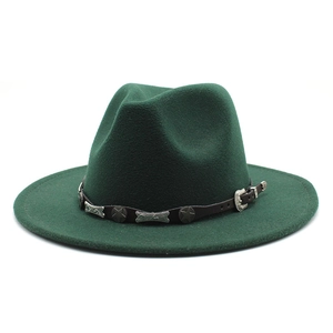 Close-up of dark green wool fedora hat with brown leather band and silver star studs