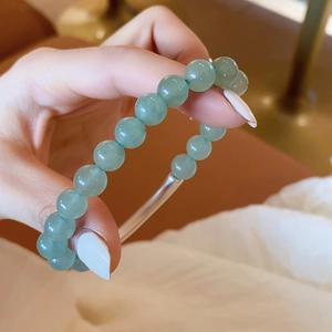 Detail view of matte green aventurine beaded bracelet with a modern clear acrylic tube connector