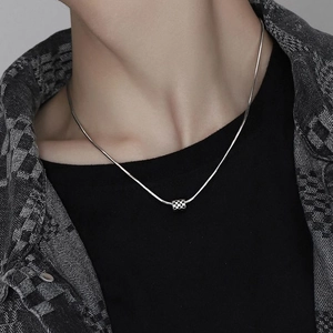 Silver snake chain necklace with black and white checkerboard cube pendant on neck