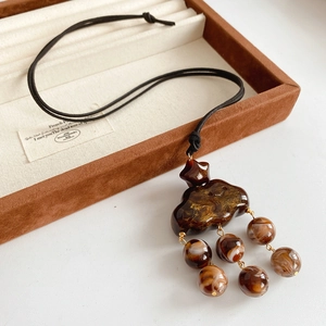 Detail of retro amber-textured resin cloud pendant with marble pattern beads