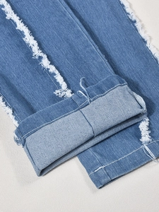 Détail du body en jean bleu avec ourlets effilochés et coutures blanches rétro