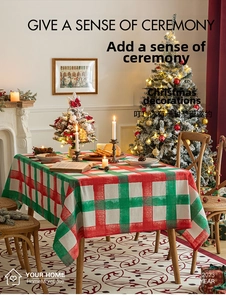 Detailed texture of red and green plaid Christmas tablecloth with festive home decorations