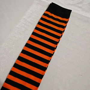 Flat lay of high-quality Christmas over-knee socks with orange and black stripes