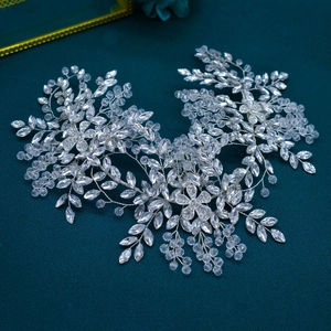 Silver bridal headband with intricate crystal floral weaving on dark teal fabric