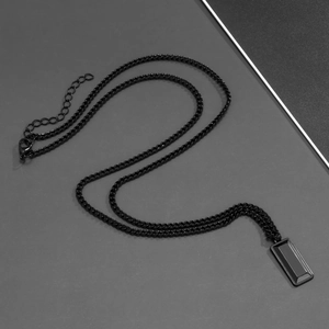 Detailed close-up of a matte black rectangular pendant with alloy chain and lobster clasp