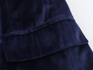 Close-up of deep blue velvet fabric showing layered ruffle details and soft texture