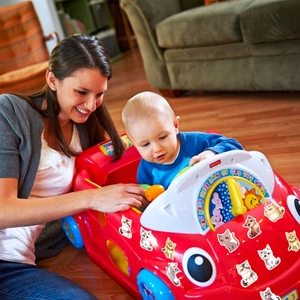Close-up of baby toy car featuring cute watercolor cat stickers in a cozy home setting