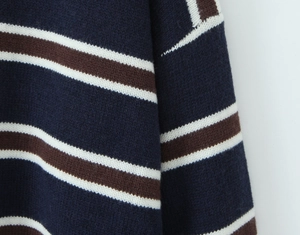 Close-up of stripes and fabric texture on a navy blue knitted polo sweater