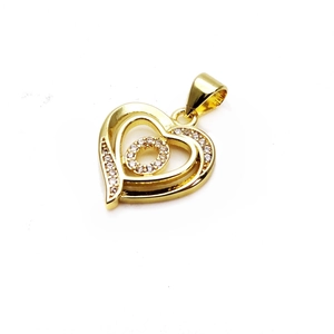 Macro view of a gold double-layer heart pendant with sparkling cubic zirconia inlay