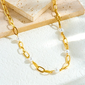 Collier chaîne en acier inoxydable doré avec perles blanches sur socle en pierre