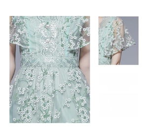 Detail der Stickerei am hellgrünen Kleid mit schmaler Taille und Paillettengürtel