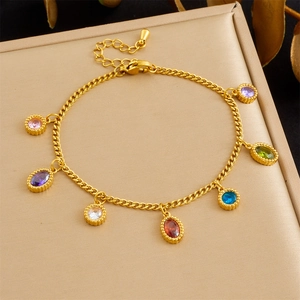 Detail of gold chain bracelet with multi-colored zircon charms and extension pendant