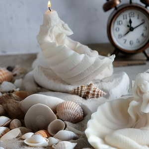 Détails de texture d'une bougie blanche en forme de coquillage sur sable avec décors
