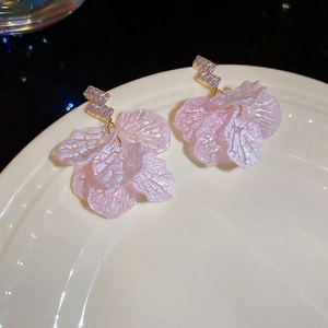 Macro view of shell petal tassel earrings with pink texture and sparkling rhinestones