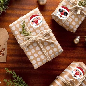 Round Santa Claus Merry Christmas stickers on kraft gift box with pine branch decor