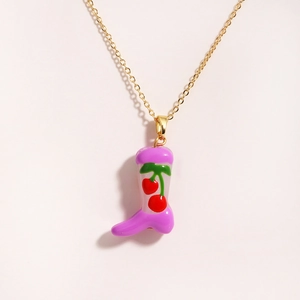 Golden necklace with pink boot pendant featuring red cherry pattern on white background