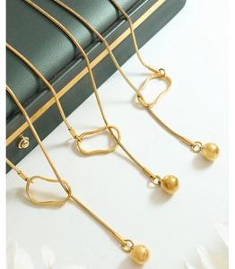Detail of 18k gold plated sweater necklaces with geometric beads and Y-shape design