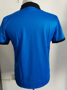 Back view of a blue polo shirt with black contrast trim on the collar and short sleeves