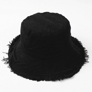 Detailed view of black canvas bucket hat with frayed edges and cotton fabric texture