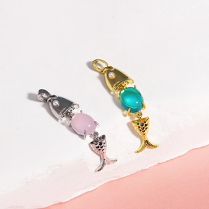 Macro shot of 18K gold and silver plated moving fish bone pendants with colorful stones