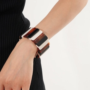 Close-up of wide stretch bracelet with black white and amber geometric resin links