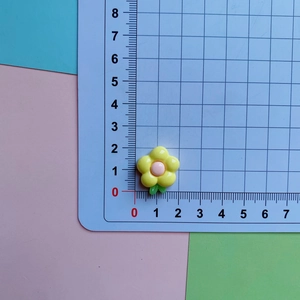 Detailed scale view of 1.8cm resin plumeria charm with yellow petals and pink center